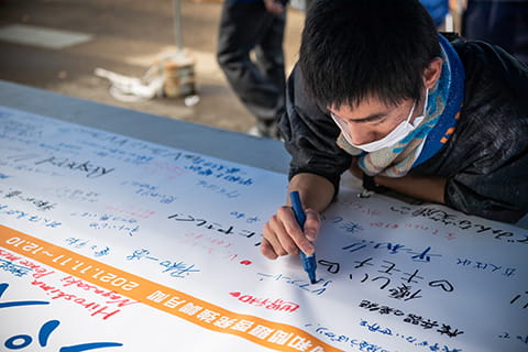 横断幕に書き込む様子